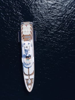 Stunning aerial shot of a luxury yacht navigating the blue waters near Olbia, Sardinia.