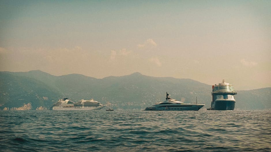 A breathtaking view of luxury yachts and cruise ships on a serene ocean with mountain backdrop.