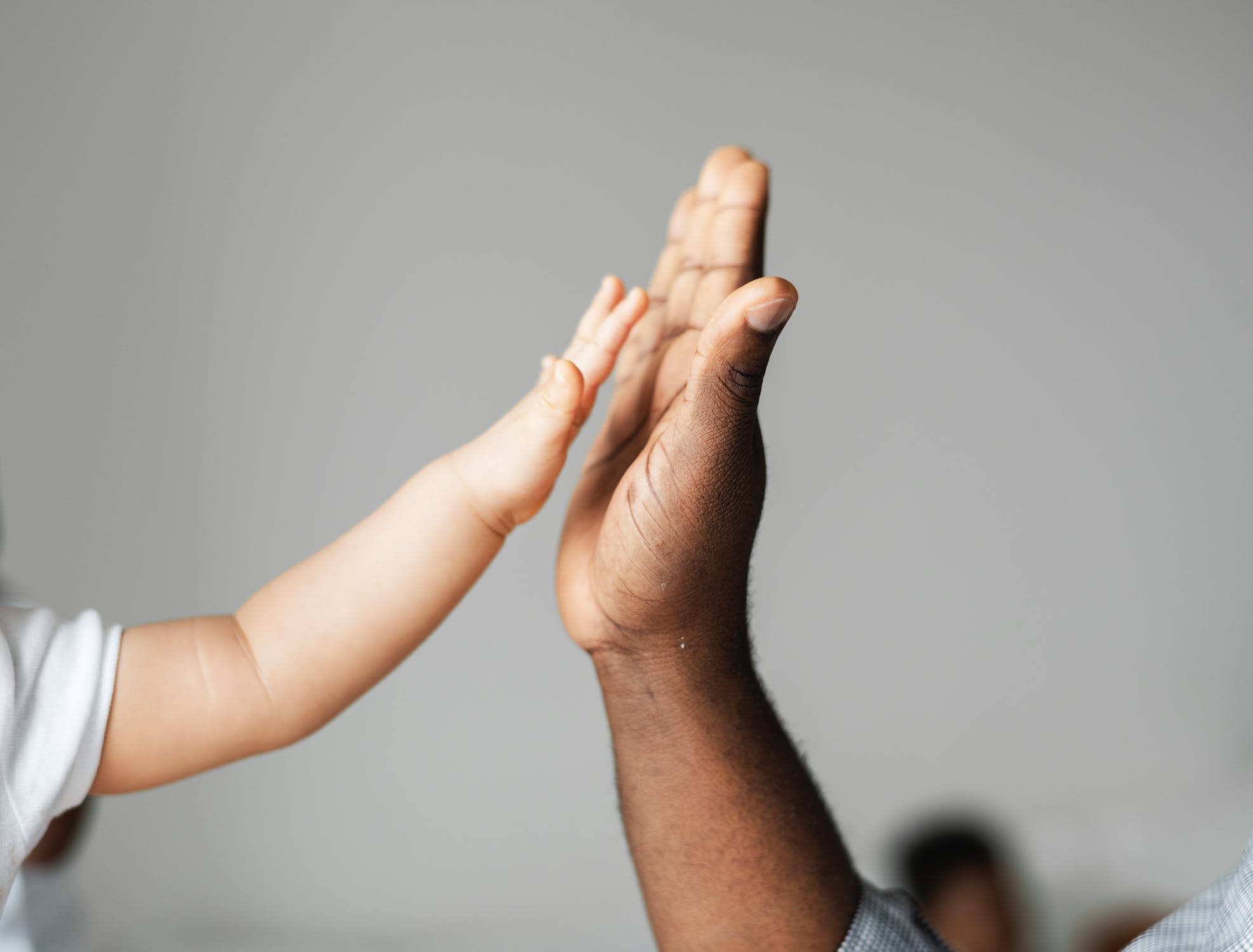 Baby high-fiving an adult