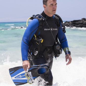 Man wearing a wetsuit walking out of the ocean